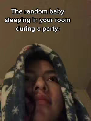 A person with a dark complexion wearing a dark hood with a printed pattern over their head. Text overlayed on the image reads: 'The random baby sleeping in your room during a party:'.