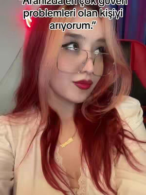 A selfie of a woman with dual-tone hair (red and blonde). She wears glasses, red lipstick, and a necklace. Text overlay in Turkish.