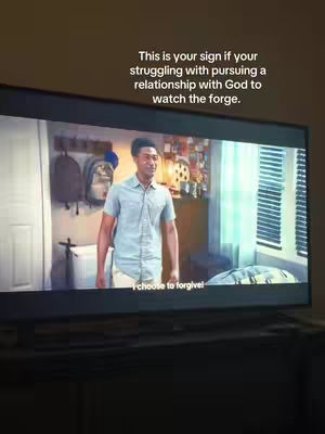 A movie frame featuring a man in a light blue button-up shirt standing in what looks like a bedroom. Behind him are a desk with some items and a window with blinds. The text overlay says, "This is your sign if you're struggling with pursuing a relationship with God to watch the forge."
