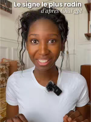 A woman with dark curly hair is facing the camera, smiling. A microphone is attached to her white shirt. Text in white is overlaid at the top.