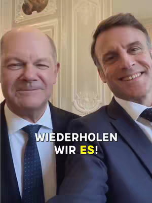 The cover image shows two men, presumably world leaders, smiling directly at the camera. They are dressed in dark suits with ties, and the background appears to be a formal, ornate room. A text overlay in a bold, white font reads 'Wiederholen wir es!'