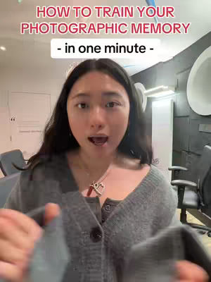 A young woman with long dark hair and a gray sweater is looking directly at the camera and speaking. Text on the image reads, 'HOW TO TRAIN YOUR PHOTOGRAPHIC MEMORY - in one minute -'. The background is a blurred office-like setting.