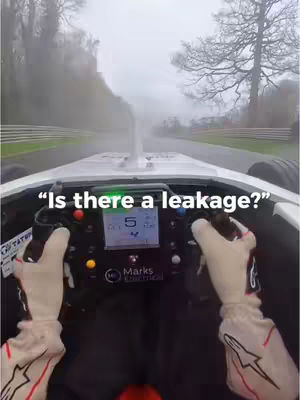 The cover image shows a first-person view from inside a race car, with the driver's hands on the steering wheel and a view of the track ahead. The car's dashboard with a speedometer and other gauges can be seen, and text overlays the image.