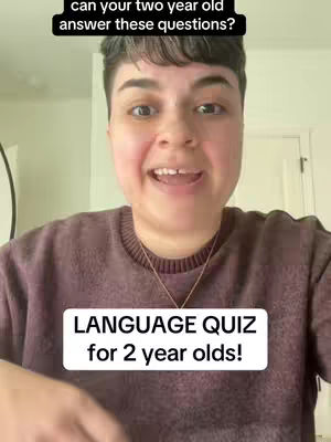 A person with short, dark hair, wearing a maroon sweater, is centered in the frame, directly facing the camera and smiling. Above them is a black rectangle containing white text, and below them is a white rectangle with black text. The background appears plain.