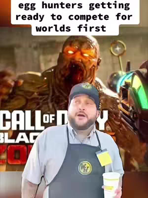 A man in a cap and apron is holding a drink, his expression is open-mouthed. Behind him is a zombie with glowing eyes from a video game, with the game's logo visible below.