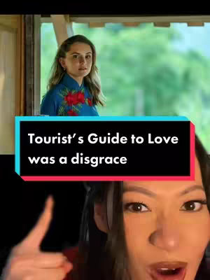 The cover image is a vertical shot. The top section features a person in a Vietnamese Ao Dai dress, looking towards the viewer and framed by a window with green foliage in the background. The bottom part of the image is a close-up of a person's face, looking straight at the viewer and expressing a dramatic expression. In the middle between the subjects, in a rectangle that contains the text: 'Tourist's Guide to Love was a disgrace'.