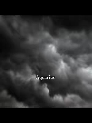 A dark, moody image featuring a cloudy sky. The clouds are dense and gray, creating a sense of overcast weather. The text 'Aquarius' is overlaid in a plain white font.