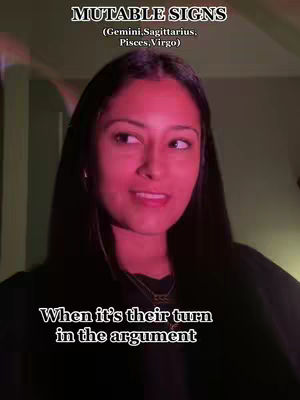 A medium shot shows a woman with long dark hair against a blurred green backdrop. She's looking to her left with a slight smile. The lighting has a pink/red hue. Text overlays read, 'MUTABLE SIGNS' and 'When it's their turn in the argument'.