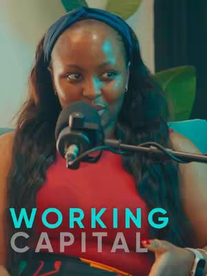 A woman wearing a red top and a blue headband speaks into a microphone. The words "WORKING CAPITAL" are overlaid on the image. The background has blurred colors.