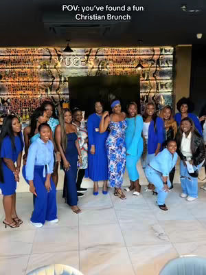 A group of diverse women poses in front of a decorative wall. They are all dressed in shades of blue, creating a cohesive and stylish visual. The setting appears to be an event space. Overlay text states 'POV: you've found a fun Christian Brunch'.