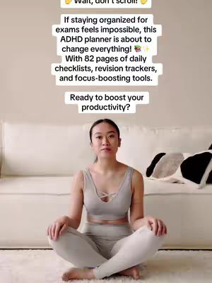 A woman sits cross-legged on a rug in front of a white couch. She wears a light gray sports bra and leggings. A white backdrop and text overlay are above her head.