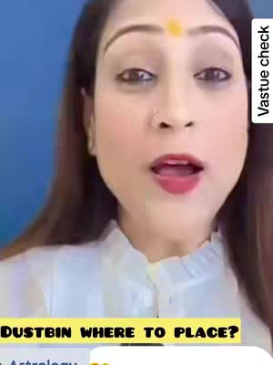A woman with fair skin and dark hair is centered, with a blue background. She's looking at the camera with an open mouth, and there is gold dot on her forehead. The text overlay is at the bottom and says "DUSTBIN WHERE TO PLACE?"