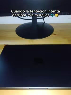 A desktop monitor rests on a wooden surface, above a laptop screen displaying a dark, blank surface. Text in white is superimposed near the monitor. The overall composition has a neutral color palette with a focus on tech and minimal design.