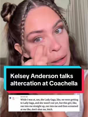 A woman with light skin and brown hair is centered in the frame, slightly angled towards the viewer. She has her hair styled in a combination of braids and buns. Her eyes are focused towards the camera, and one hand is raised to touch below her eye in a gesture that suggests contemplation or distress. A blue and black rectangular overlay at the bottom of the image displays a caption in white text. Below that, a white box contains text, presumably a quote or snippet of speech. The background is a blurred indoor setting, possibly a wall or curtain. The overall composition is a selfie-style shot, conveying a sense of personal narrative or commentary.