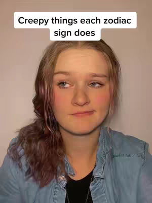 A close-up shot of a young woman with fair skin and light brown hair, styled in a side part with a braid. She has a slightly puzzled expression on her face, looking off to the side. A text overlay at the top reads, "Creepy things each zodiac sign does."