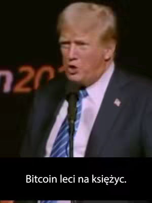 The cover image shows a medium shot of Donald Trump speaking into a microphone. He is wearing a dark suit, a blue tie with white stripes, and a white shirt. The background is dark, and there is text overlayed at the bottom in a white font.