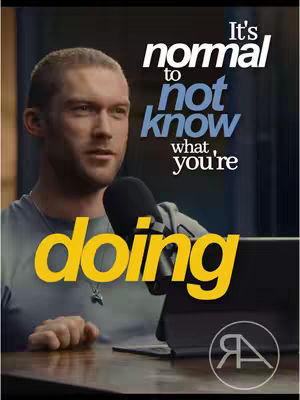 The cover image features a man with short hair, facing slightly left, set against a blurred background that suggests an interior. Text overlays dominate the top and bottom portions, using white and yellow fonts on a dark background, respectively. A microphone and a portion of a digital tablet are visible, hinting at a podcast or interview setting. The overall lighting is soft, highlighting the man's face.