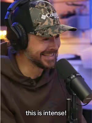 A man wearing a camo baseball cap and headphones sits in front of a microphone, smiling slightly. Text overlayed on the bottom of the image reads, “this is intense!”