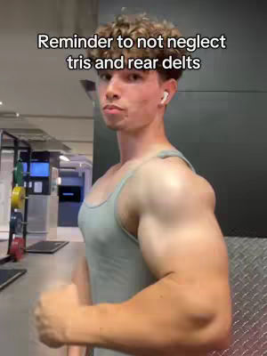 A man flexing his arm in a gym setting, tank top, text overlay indicating it is a reminder to not neglect certain muscle groups.