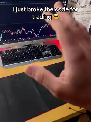 The cover image shows a person's hand partially obscuring a computer screen displaying a stock chart, a keyboard, and part of a desktop. The text overlay reads "I just broke the code for trading". The foreground is dominated by the hand, partially covering the monitor. The composition suggests a focus on trading or finance.
