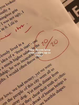 The image is a close-up shot of a piece of paper with handwritten text. Red ink is used to circle the score of 20/20 and to also write the question: 'how do you keep your grades up so high?' The paper appears to be a test or assignment with a high grade.