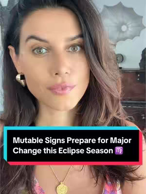 A woman with long brown hair is centered in the frame, looking directly at the camera with a subtle expression. She has light skin, and her hair frames her face. Overlaid at the bottom is a rectangular text box with a red-to-blue gradient, containing the text: 'Mutable Signs Prepare for Major Change this Eclipse Season', with a Libra symbol at the end.