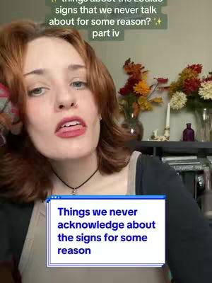 A person with auburn hair and fair skin looks slightly off-camera with their mouth open. They're wearing a black top and a necklace, and a graphic overlay features text. Plants and decorative items are visible in the blurred background.