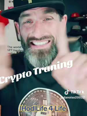 A man with a beard and a black hat is smiling at the camera, giving a thumbs up. The text "Crypto Traning" is overlayed on the image. Underneath him is a Bitcoin logo.