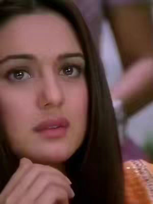 A close-up shot of a woman's face with a concerned expression. Her eyes are wide, and her lips are slightly parted. Her dark hair frames her face.