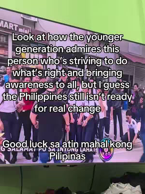 The image shows a live TV screen displaying a crowd of people, possibly in a public space. Text overlays are present, conveying a message about the Philippines and the younger generation's admiration for someone striving for change. The composition is straightforward with the focus on the text and the depicted scene on the screen.