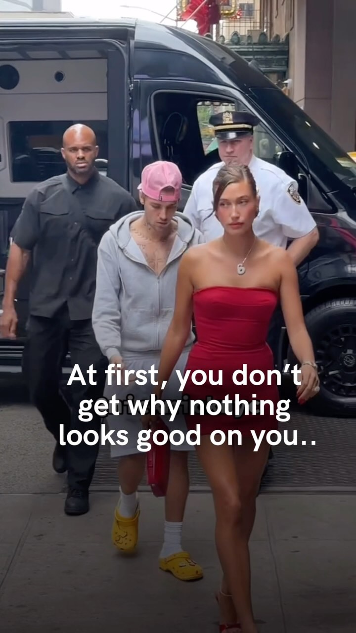 An image depicts a celebrity couple exiting a black van in front of a building. The woman is wearing a red strapless dress, while the man is in casual attire. Text overlayed on the image reads, "At first, you don't get why nothing looks good on you."
