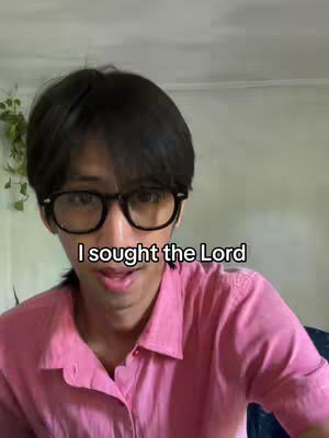 A person wearing glasses and a pink shirt, with text overlayed on the image.