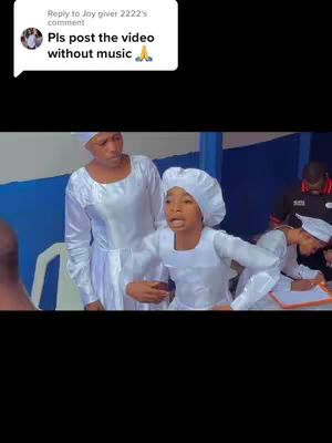 The cover image features two women in white robes and head coverings, with a comment box in the upper left corner that says, 'Pls post the video without music.' The background behind them is a mix of blue and white, suggesting a church setting or similar. The woman in the foreground is speaking with an animated expression and her right arm is bent at the elbow in front of her. To the left, a woman looks towards her and the person is facing towards the viewers. The color palette is dominated by white and blue, with accents from the comment box and background. The overall composition focuses on the two subjects, possibly in a scene of religious worship or community.