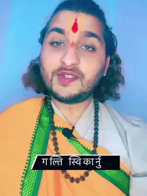 A man with a red mark on his forehead is shown speaking. He wears a yellow cloth and a black beaded necklace. The background is light blue. Text overlay is a caption in white.