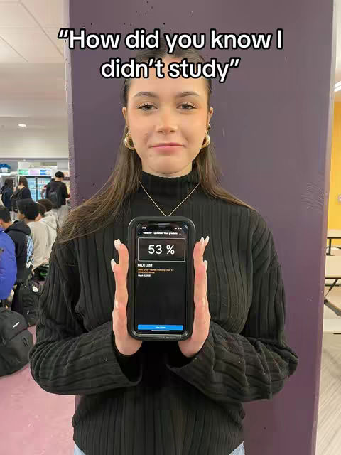 A young woman stands in front of a purple wall holding a phone displaying a test score. Text overlays read, "How did you know I didn't study."