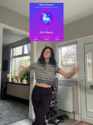 The cover image shows a woman dancing with her arms outstretched. Behind her is a sign with astrological matching information, which suggests a relationship connection. The background has a room setting.
