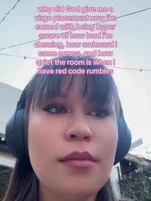 A close-up shot of a woman's face wearing headphones, with overlaid text in a light color. The woman looks directly at the camera with a neutral expression. The background is blurred, suggesting an outdoor setting.