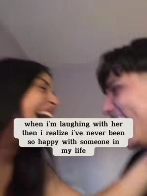 Two people face each other, likely laughing, with a text box added over their faces. The image is blurry, suggesting movement or a candid moment, and the color palette is muted.