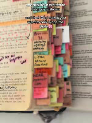 A close-up shot shows an open book with many colorful sticky notes used as bookmarks, revealing text and handwritten annotations. The background is blurred.