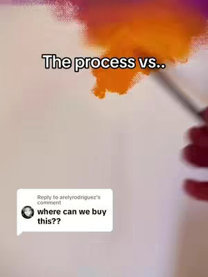 The image shows a close-up of a canvas being painted. The top portion of the image contains an orange and pink abstract brushstroke. A hand holding a paintbrush is visible on the right. In the bottom left corner, there is a comment bubble from a social media user asking "where can we buy this??“. Overlayed at the top, in bold black text, it states "The process vs.."