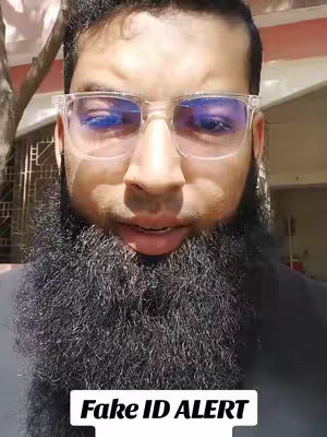 A man with a full, dark beard, wearing clear-framed glasses, and looking at the camera with a neutral expression. A text overlay at the bottom reads 'Fake ID ALERT' in a white, bold font against a black rectangle.