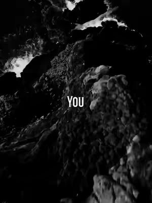 A grayscale image depicts a textured, rocky landscape. The composition is dominated by abstract shapes with uneven surfaces, possibly representing mountains or cliffs against a dark, possibly cloudy sky. The word "YOU" is superimposed in a clean white font.