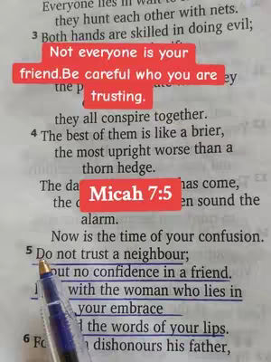 The image displays an open book's pages, featuring printed text and highlighted lines with a blue pen. A red rectangular overlay with white text covers a portion of the text. The overall composition uses natural lighting and a simple, direct presentation.