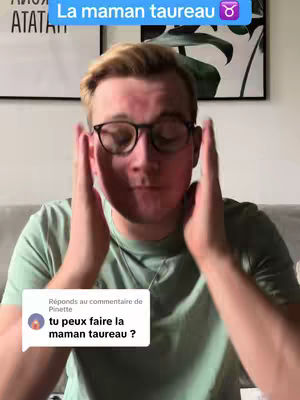 A man is centered in the frame, staring at the camera with hands up near his face, palms facing inward. He wears glasses and a light green t-shirt. Text in a blue box overlaying on the top of the image reads "La maman taureau", with a Taurus symbol. A comment bubble on the bottom left contains text as well.