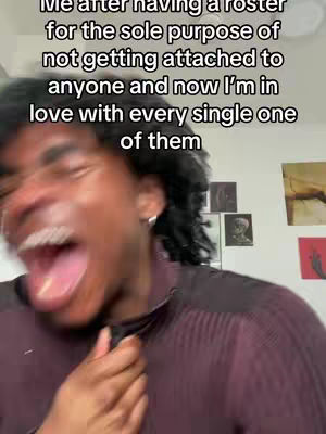 A blurry, close-up shot of a Black man with short, dark hair and a slight smile. He is looking towards the camera with his mouth wide open, as if mid-speech or laughter. The background is out of focus.