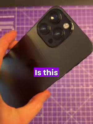 The cover image shows a black iPhone 14 Pro Max held by a hand against a purple grid background. A text overlay asking 'Is this' is present in a bright rectangle.