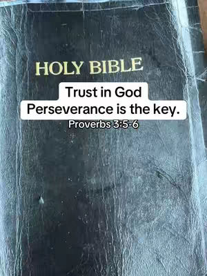 The cover image shows a close-up of a closed, well-worn black Bible. In the center, a white rectangular box contains the text overlay: 'Trust in God, Perseverance is the key. Proverbs 3:5-6'. The Bible appears to be resting on a textured surface.
