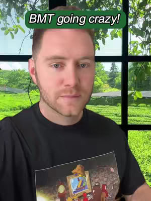 A man is centered in the frame, wearing a black t-shirt with a graphic on the front. The background features a window with a green, natural scene visible outside. The text overlay says "BMT going crazy!" above the man's head.