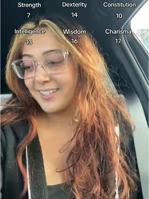 A smiling woman with long, multi-colored hair and glasses is sitting in a car. Overlayed on the image are Dungeons and Dragons stats.