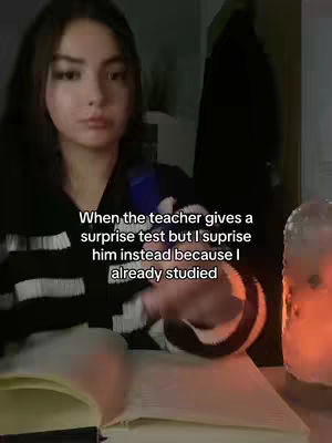 A young woman with dark hair and wearing a black and white striped shirt is looking towards the camera while a candle is lighting beside her. The hook text is overlaid on the image, which is a quote related to studying.